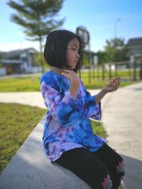 Girl looking away while sitting in park