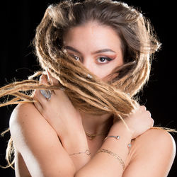 Portrait of beautiful woman against black background
