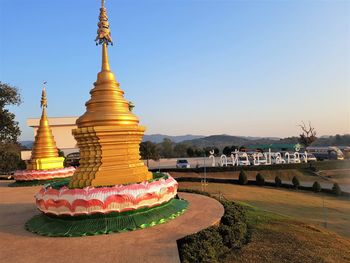 Temple by building against clear sky