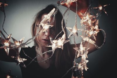 Close-up of woman with christmas lights