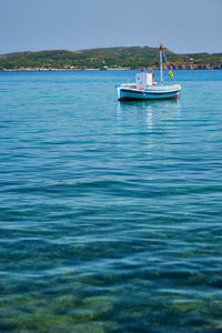 Sailboat sailing in sea against blue sky