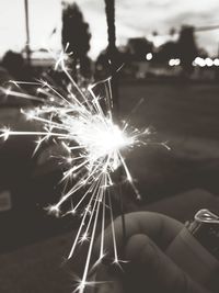 Hand holding sparkler at night