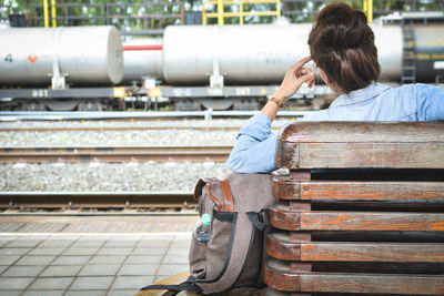 Woman sitting on railway station platform