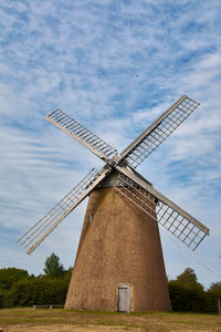 Traditional windmill on field against sky