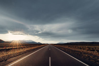 Empty road along countryside landscape