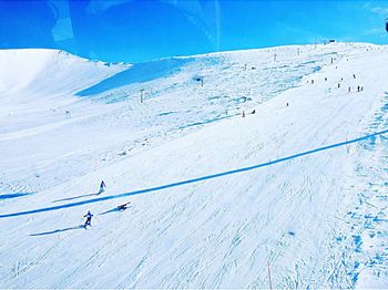 People skiing on snow covered landscape