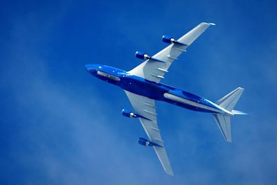 Low angle view of airplane in blue sky