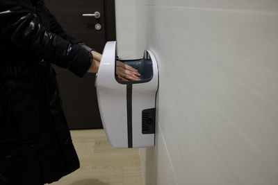 Midsection of woman using hand dryer