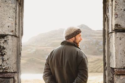 Rear view of man looking standing against mountains