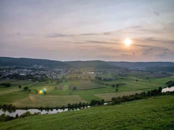 Scenic view of field against sky at sunset