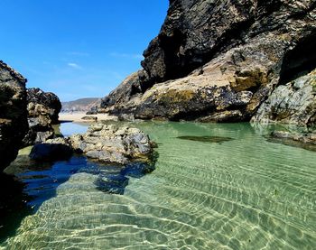 Rock formation in sea against sky