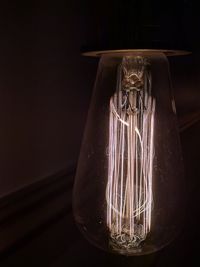 Close-up of illuminated light bulb in darkroom