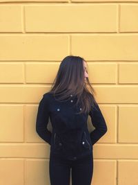 Woman standing against brick wall