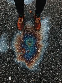 Low section of man standing on wet street