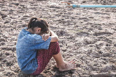 High angle view of girl sitting on land