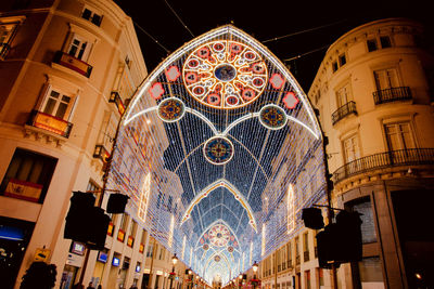 Low angle view of illuminated lights in building at night