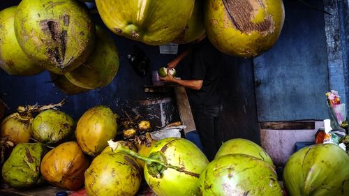 Side view of man selling coconuts at market