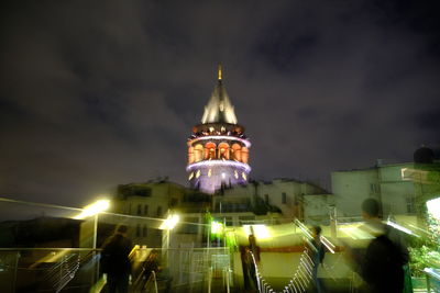 People on illuminated building at night