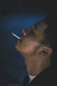 Portrait of young man smoking cigarette