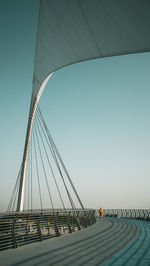 Low angle view of suspension bridge against clear blue sky