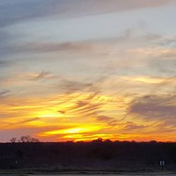 Scenic view of landscape against sky at sunset