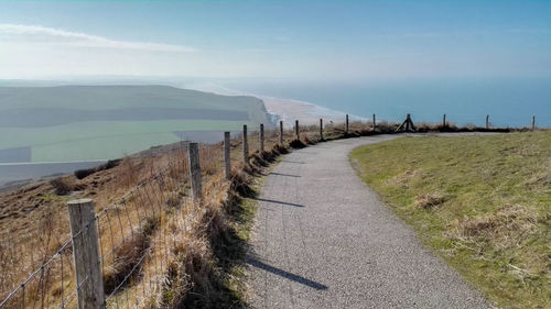 Road leading towards mountains against sky