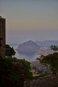 Scenic view of sea and buildings against sky during sunset