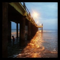 Pier on sea at sunset