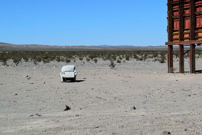 Armchair on landscape against clear sky