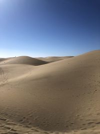 Scenic view of desert against clear blue sky