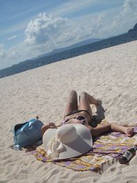 View of woman sunbathing on beach