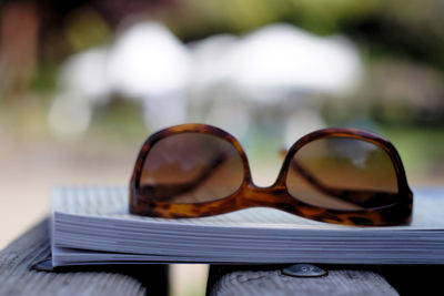 Close-up of sunglasses and book on table