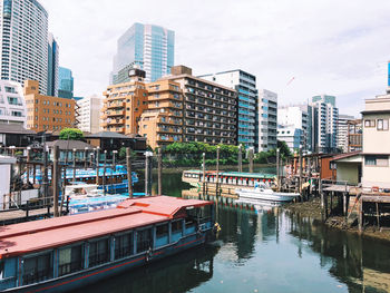 Canal amidst buildings in city against sky