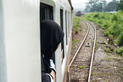 Close-up of person in train at railroad track