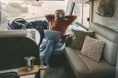 Woman using mobile phone while sitting on sofa at home