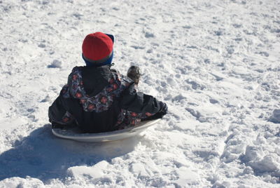 Boy tobogganing on snow