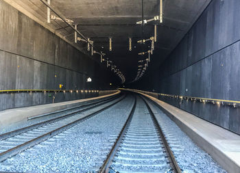 Railroad tracks in illuminated tunnel