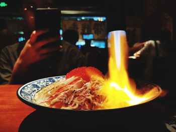 Close-up of hand holding tea light candle