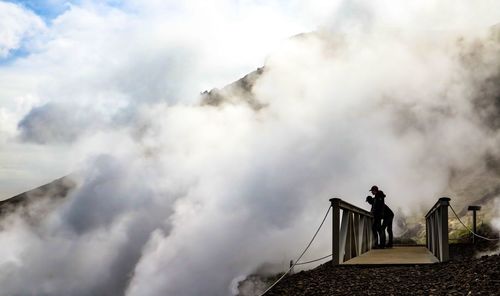 People standing on mountain against sky