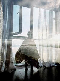 Built structure against sky seen through window