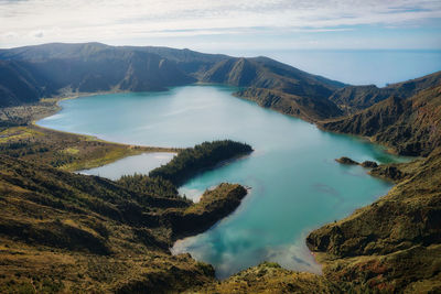 High angle view of lake and mountains against sky