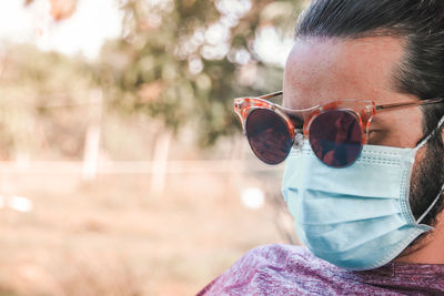 Portrait of young man wearing sunglasses and medical mask