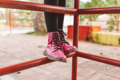 Low section of person wearing red shoes standing on jungle gym