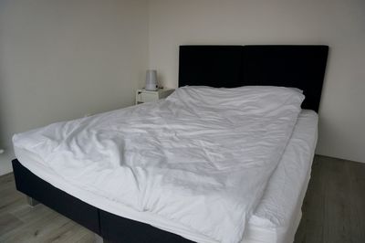 White blanket on bed against wall at home