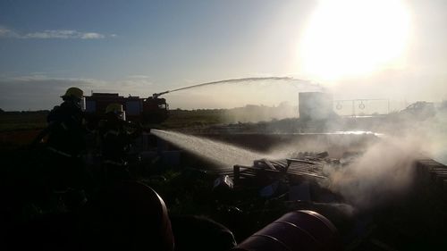 Firefighters spraying water on vehicle