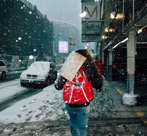 Rear view of person in city street during winter