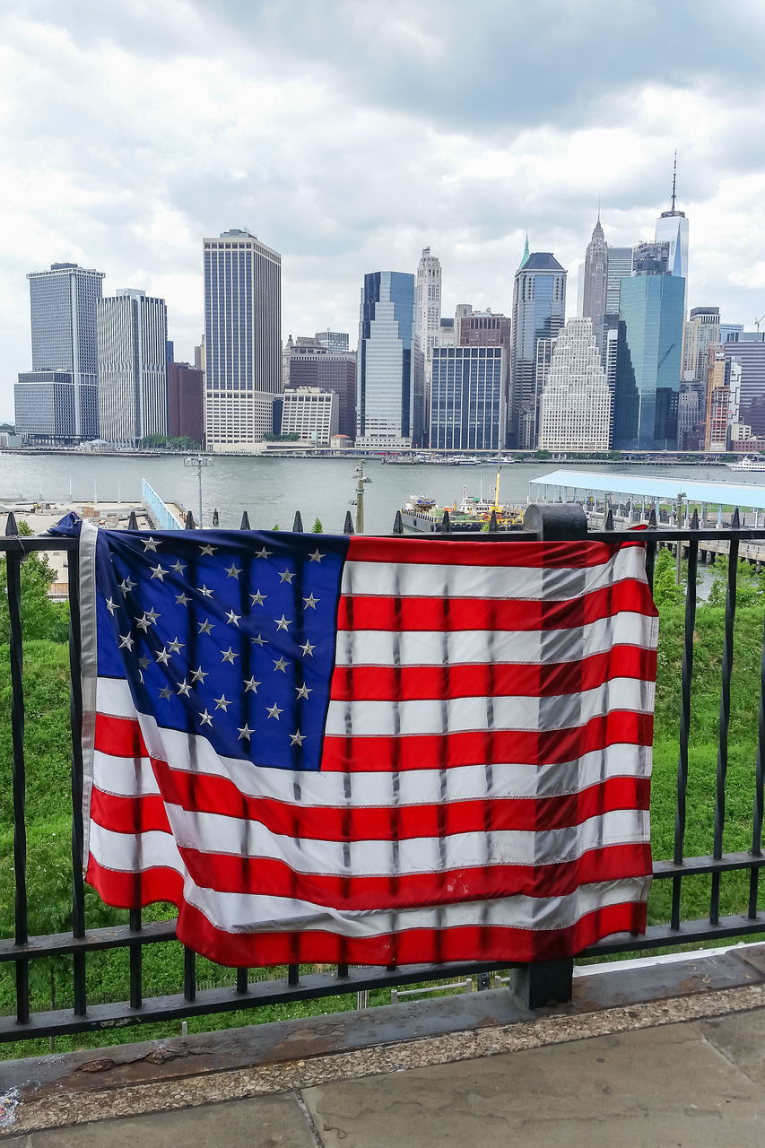 CLOSE-UP OF FLAG AGAINST CITY