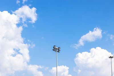 Low angle view of floodlight against blue sky