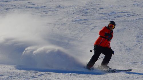 Full length of girl snowboarding on snowy field