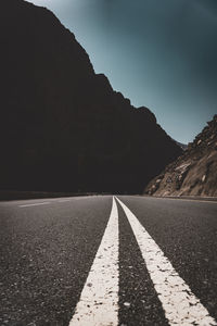 Empty road by mountain against sky